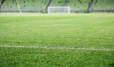 Estádio de futebol com arquibancada ao fundo.